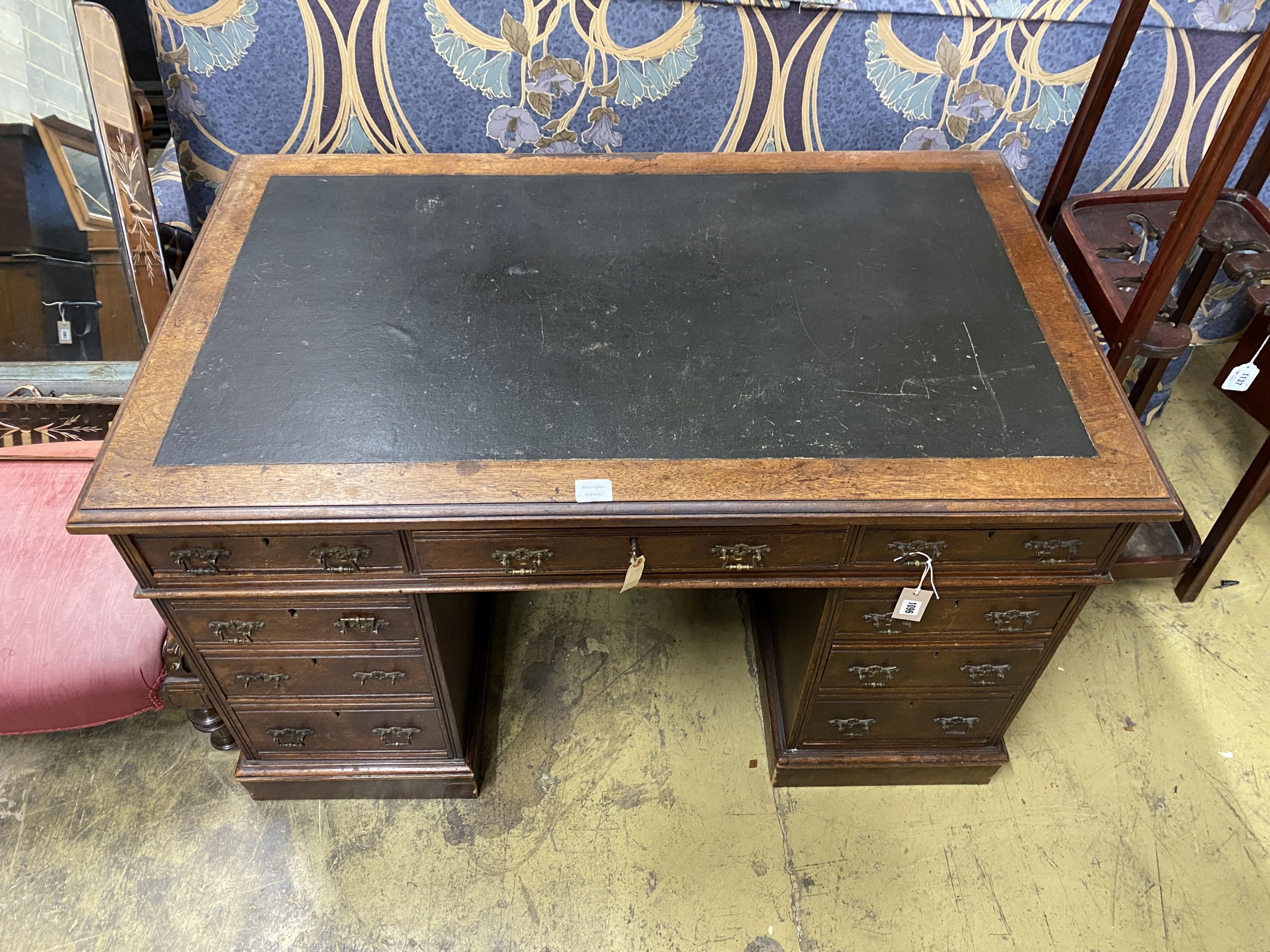 A late Victorian walnut nine drawer pedestal desk, length 122cm, depth 73cm, height 75cm